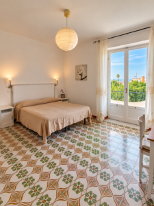 Il balcone vista giardino mediterraneo nell'appartamento bilocale Il Pino nel Villa Olivia Residence a Forio, Ischia