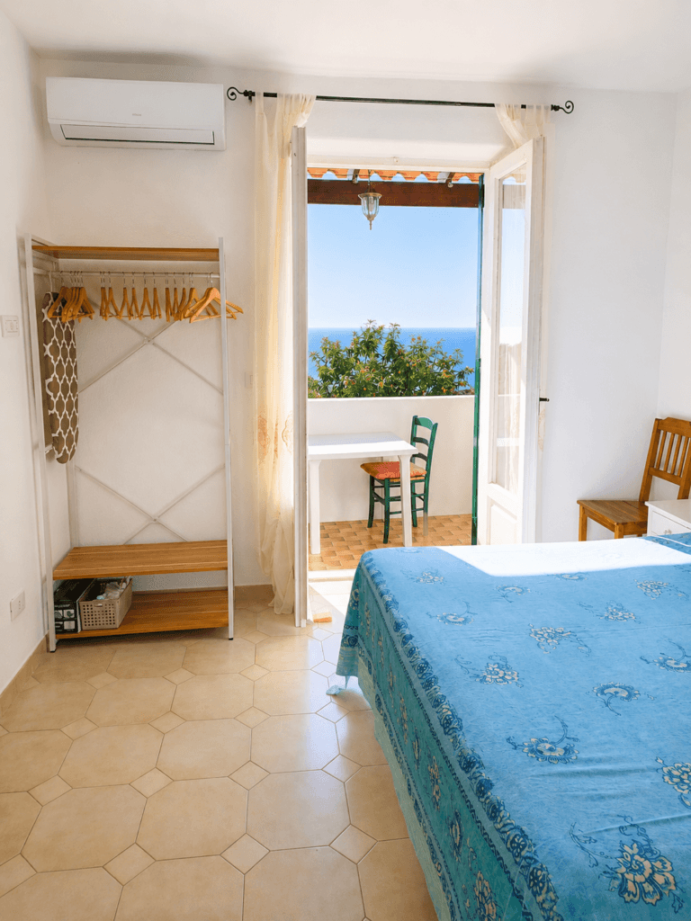 Il piccolo balcone vista vigneto e mare, arredato con tavolo esedie per due racconta il ritmo lento della vacanza - La quercia di Villa Olivia, ischia